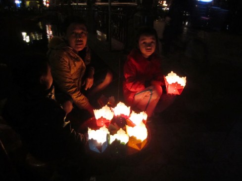 Hội An - Theo mẹ bán hoa đăng cho du khách mua thả xuống sông Hoài, mùa Đông 2012 - Hoi An, selling floating candles on Hoai River bank  - Photo: vandungsilk